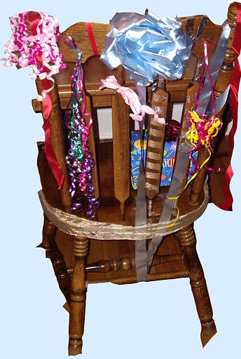 High-back wooden chair with painted symbols and a green cushion